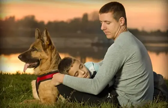 A man and his son with their dog.